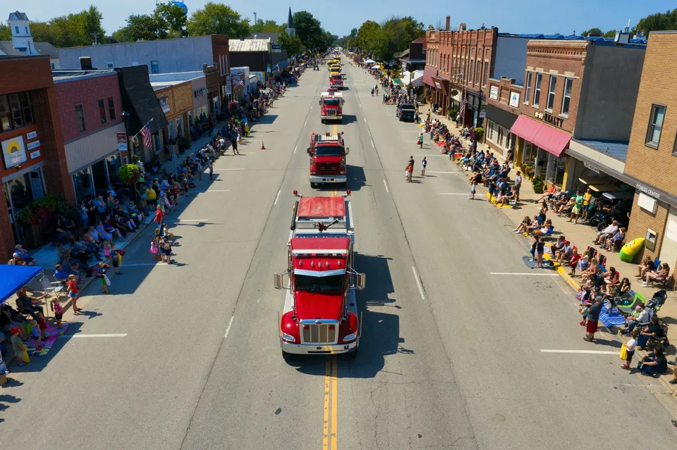 Aerial shot of a vibrant parade on a sunny day in Plainview, Minnesota.
