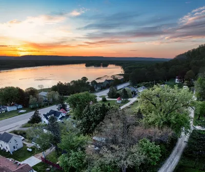 A stunning sunset over Reads Landing, Minnesota showing a lakeside townscape with vibrant skies.